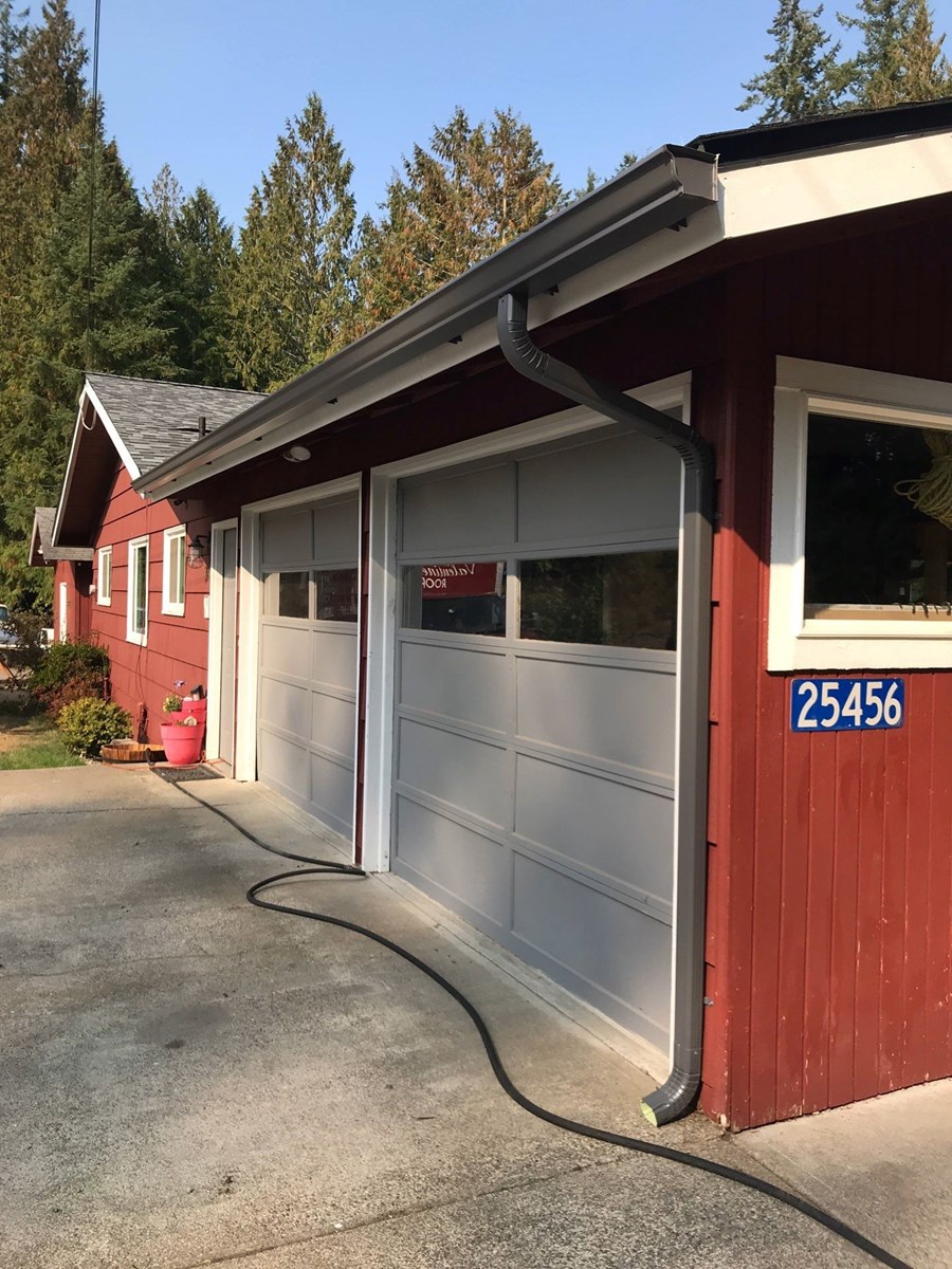 New gutters and downspouts installed on garage