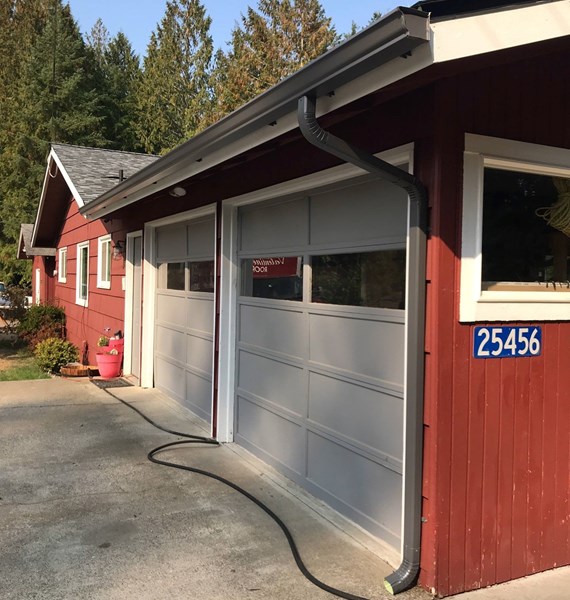 New gutters and downspouts installed on garage